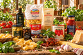 Italian pantry assortment with pasta, sauces, olive oil, cheese, and tomatoes on table