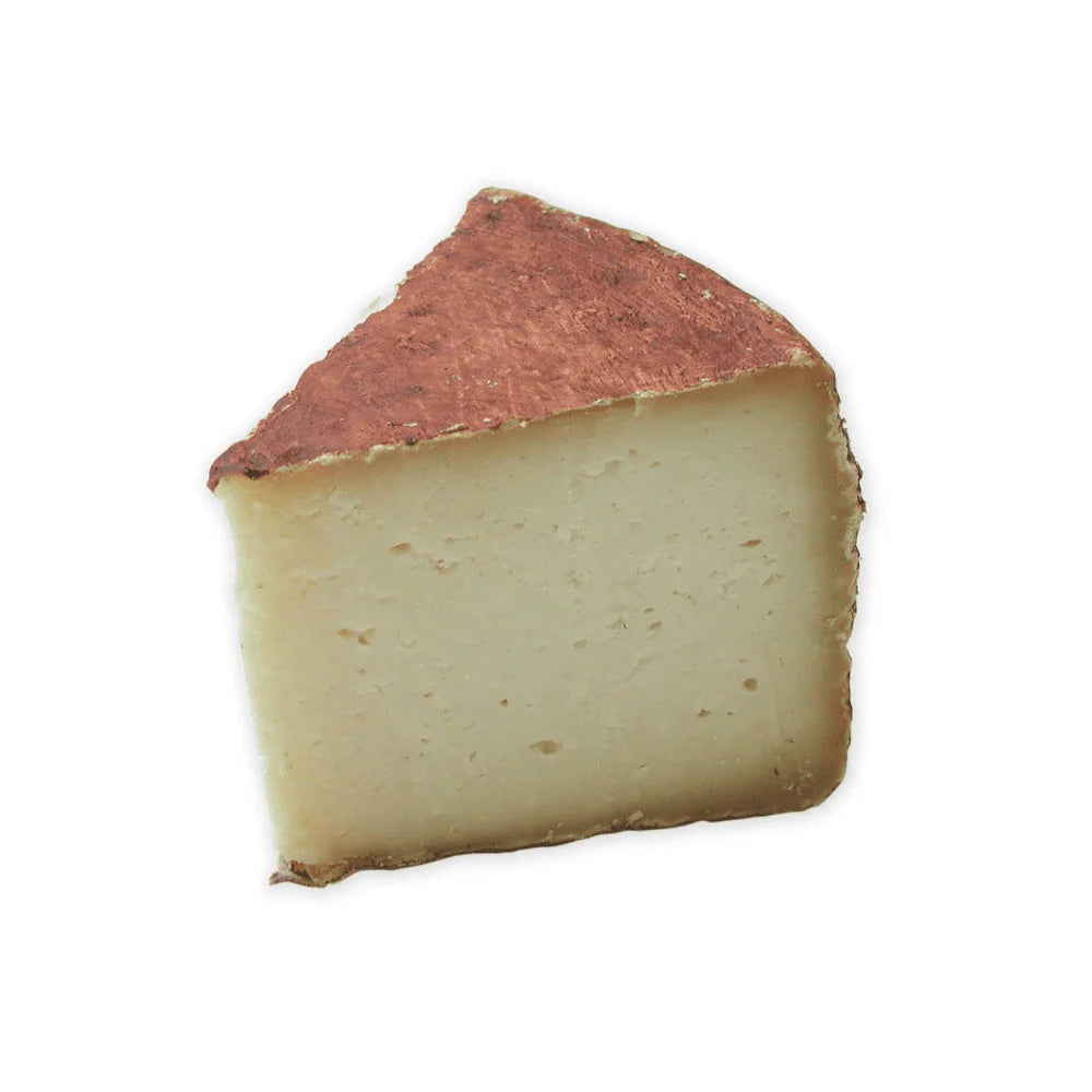 Pecorino Sardo cheese wedge with reddish-brown rind and pale interior